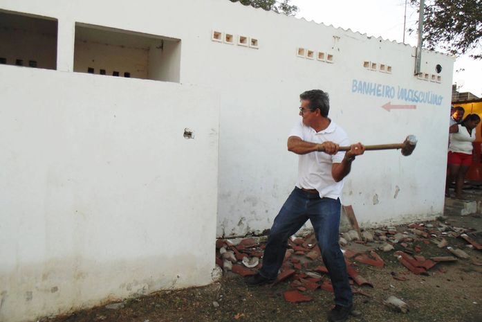 Prefeito Flávio Almeida (PMDB) na derrubada dos banheiros com martelo em mãos