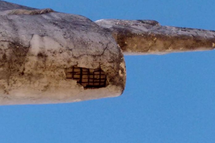 Parte exposta abaixo do braço esquerdo da imagem.