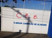 Vídeo mostra homem pichando entrada do CT do CSA com as cores do CRB