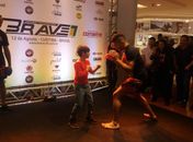 Carl Booth brinca com uma criança no treino aberto do Brave 8, em Curitiba (Foto: Alexandre Fernandes)